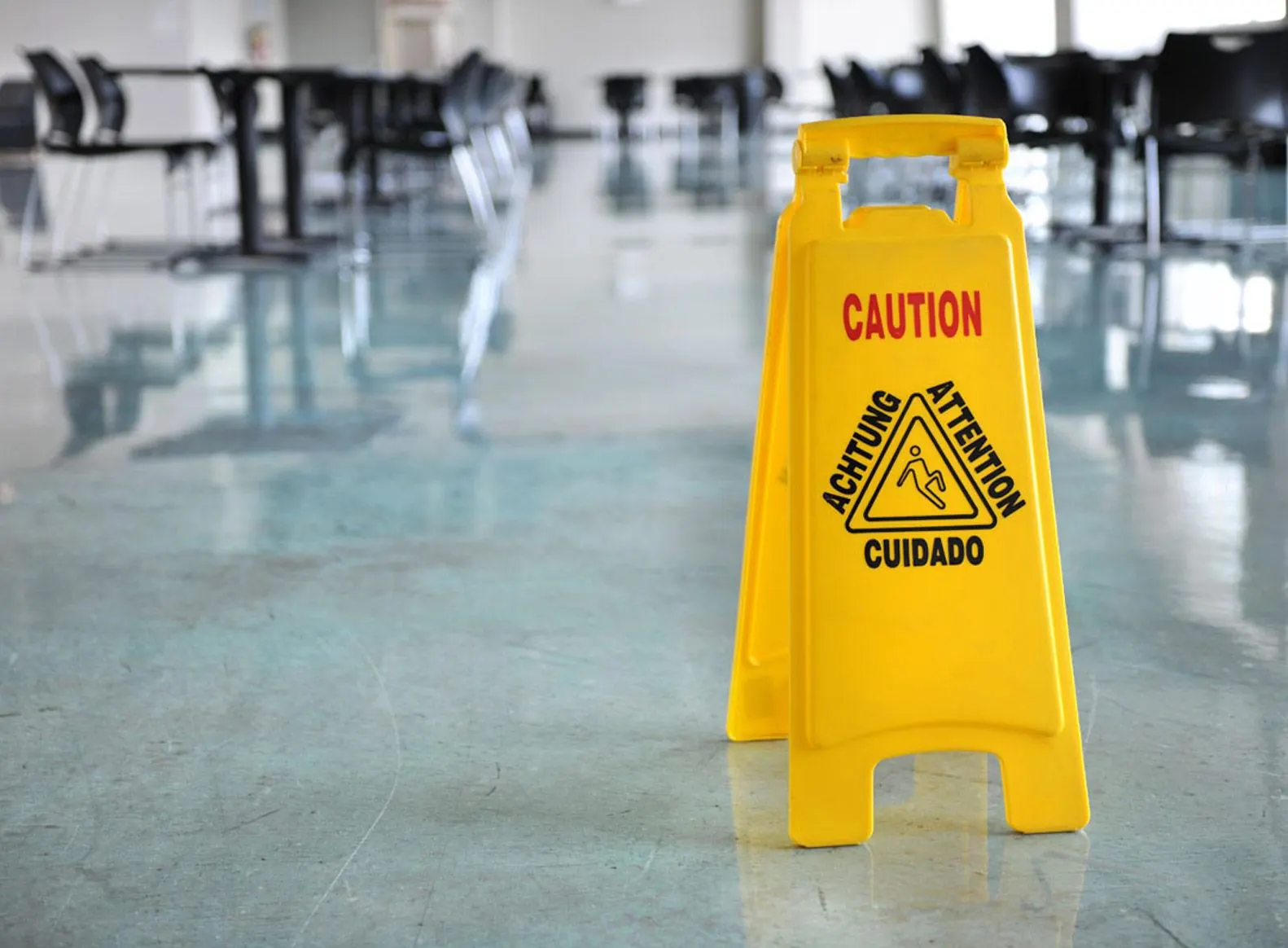 Yellow Caution / Cuidado wet floor sign on a shiny floor