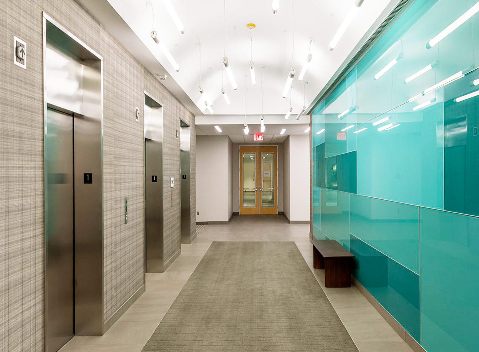 Elevator lobby with teal glass wall
